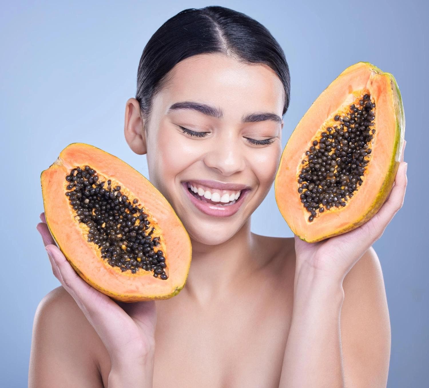 Woman holding fresh papaya smiling, symbolizing natural fruit enzyme peel benefits – Ormedic Lift by Image Skincare in Berlin.