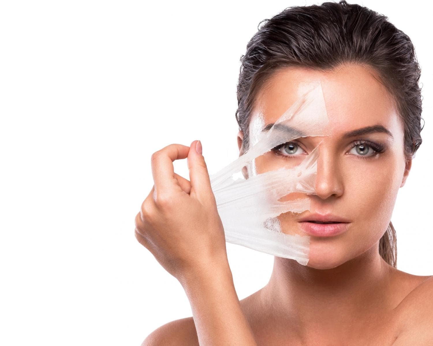 Woman peeling off facial mask revealing smooth skin after professional exfoliation treatment