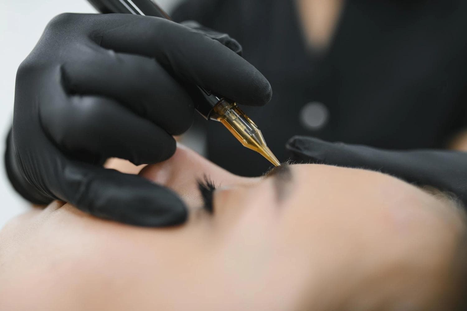 Nahaufnahme einer nicht-laserbasierten dauerhaften Entfernung von Augenbrauen-Make-up in Berlin mit professioneller Tätowiermaschine
