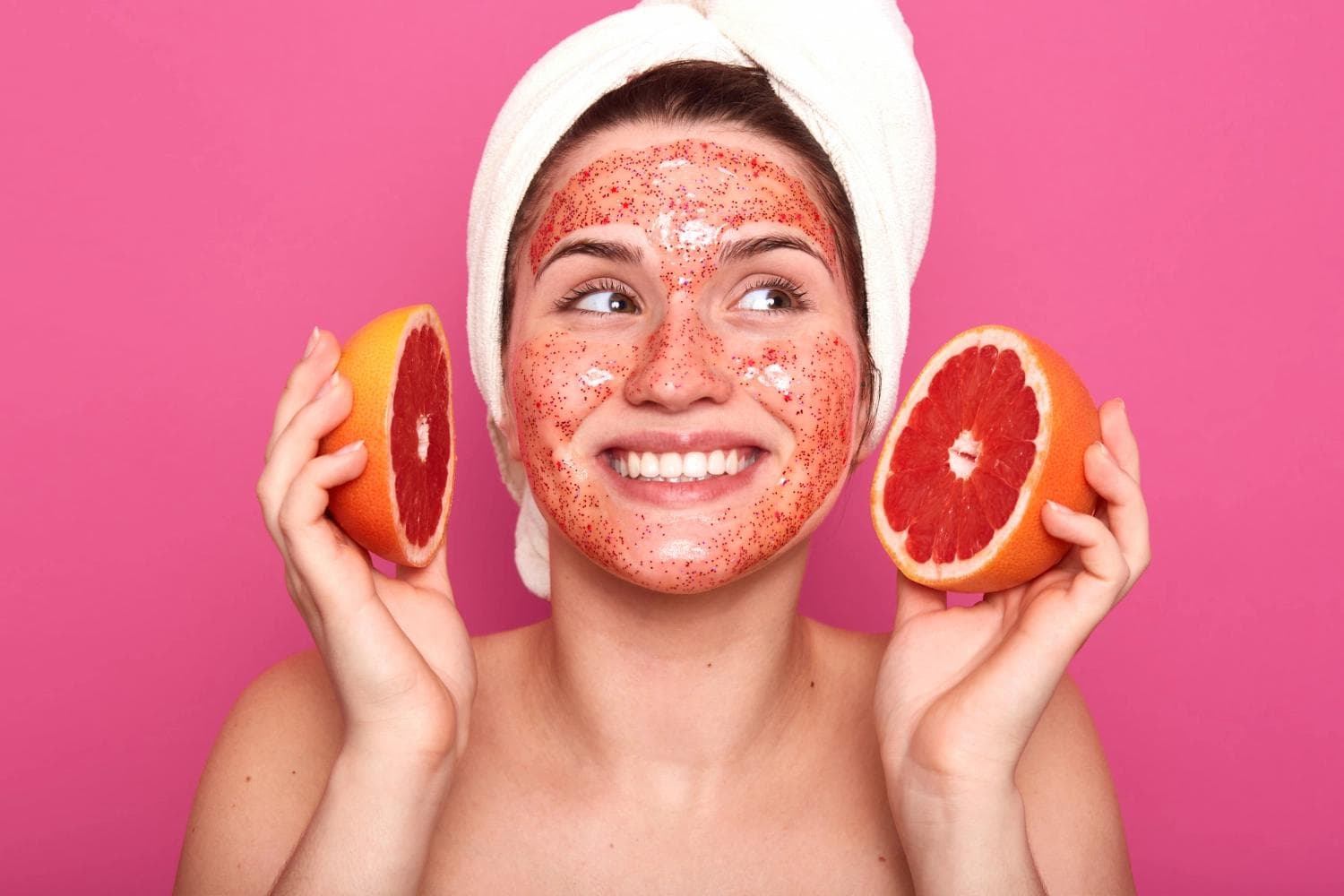 Woman with grapefruit face mask smiling after fruit acid peeling facial treatment in Berlin